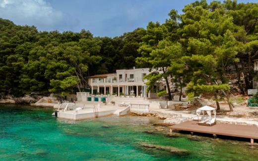 Two-storey luxury villa with terrace and boat dock, surrounded by forest 