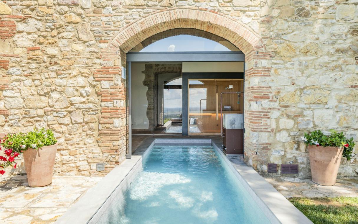 Indoor/outdoor pool leading to spa area view brick archway