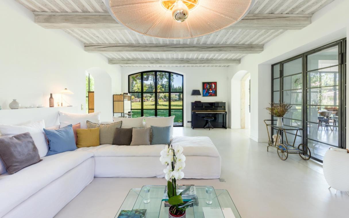 Open-plan living room with white sofas and a piano