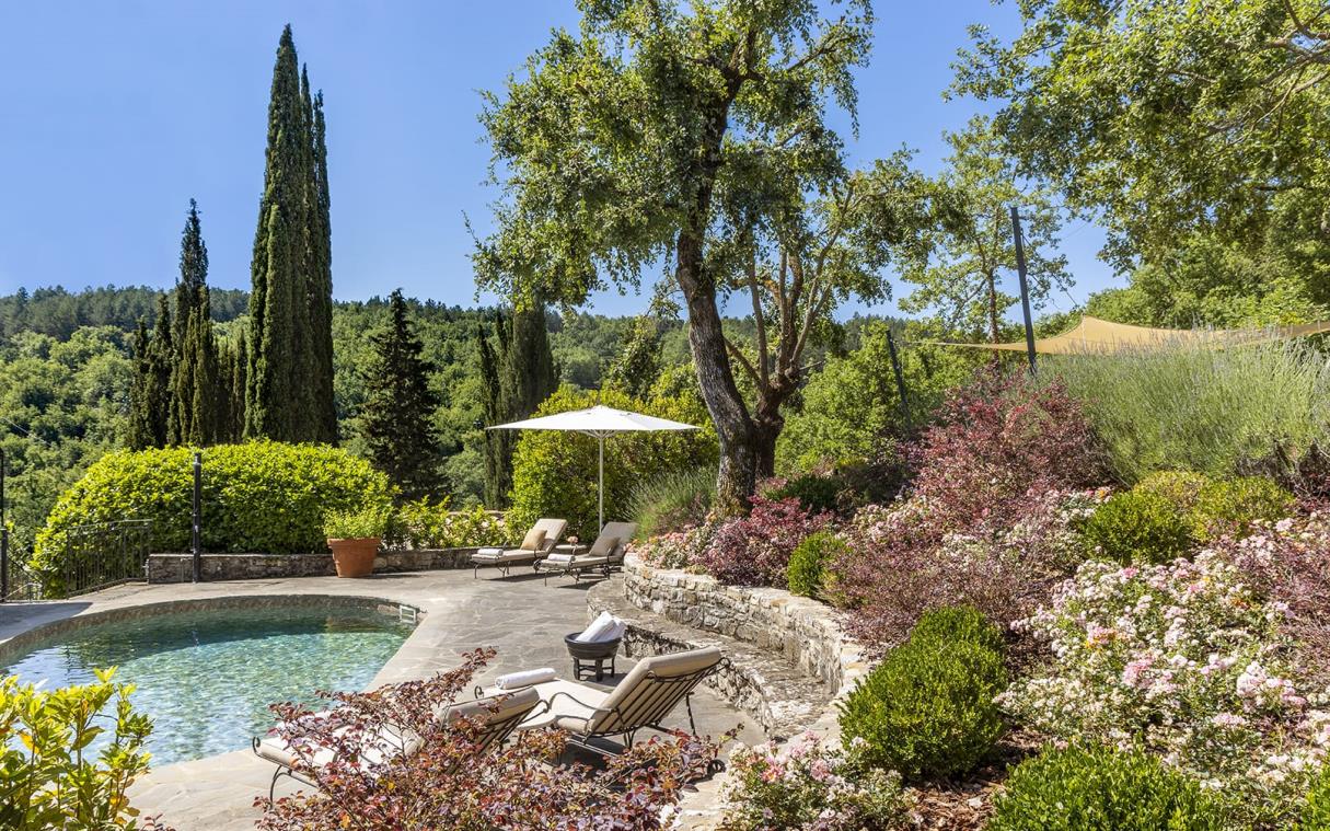 Swimming pool surrounded by flowers and trees